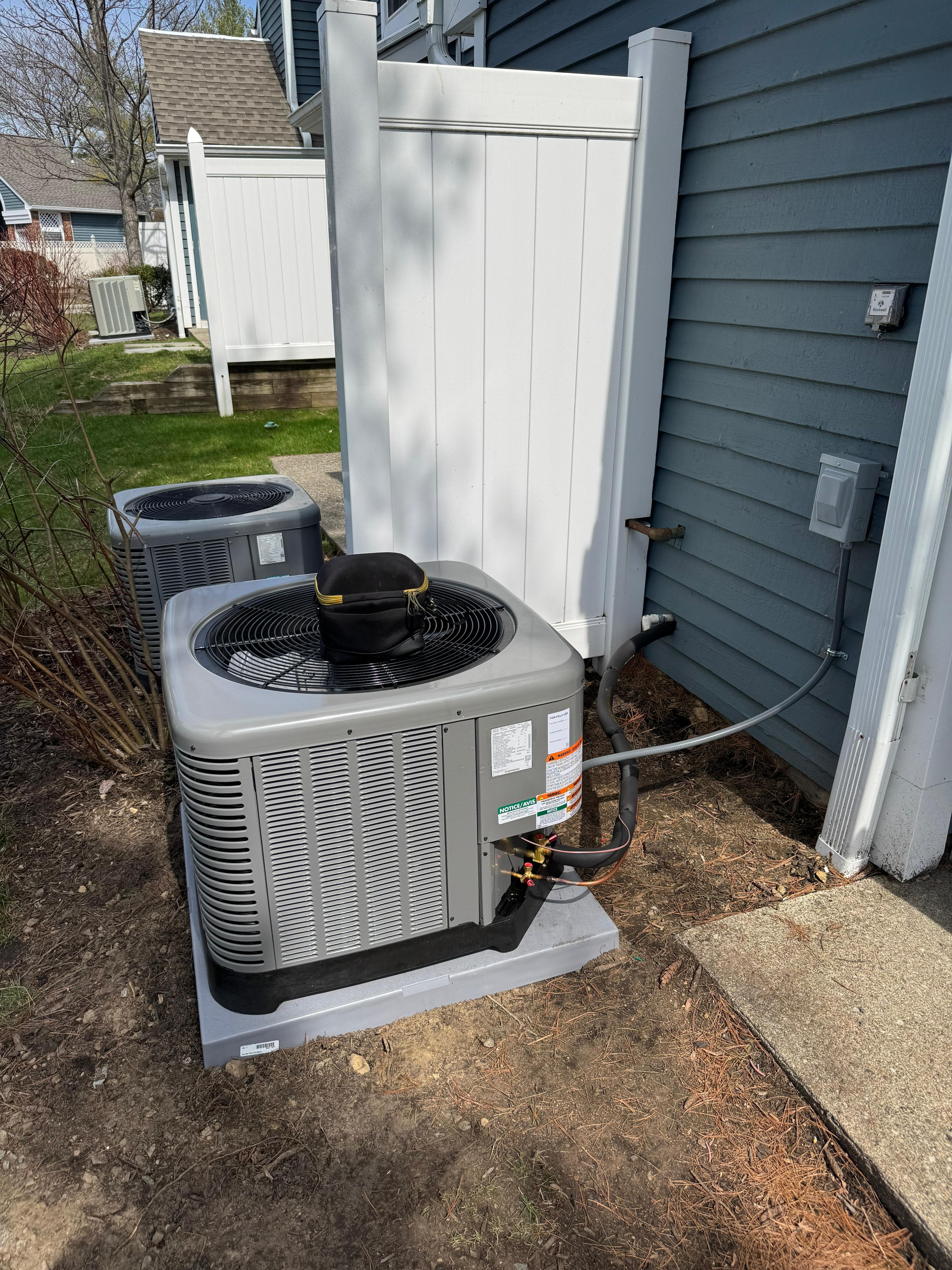 Dual outdoor heat pump units at a residence