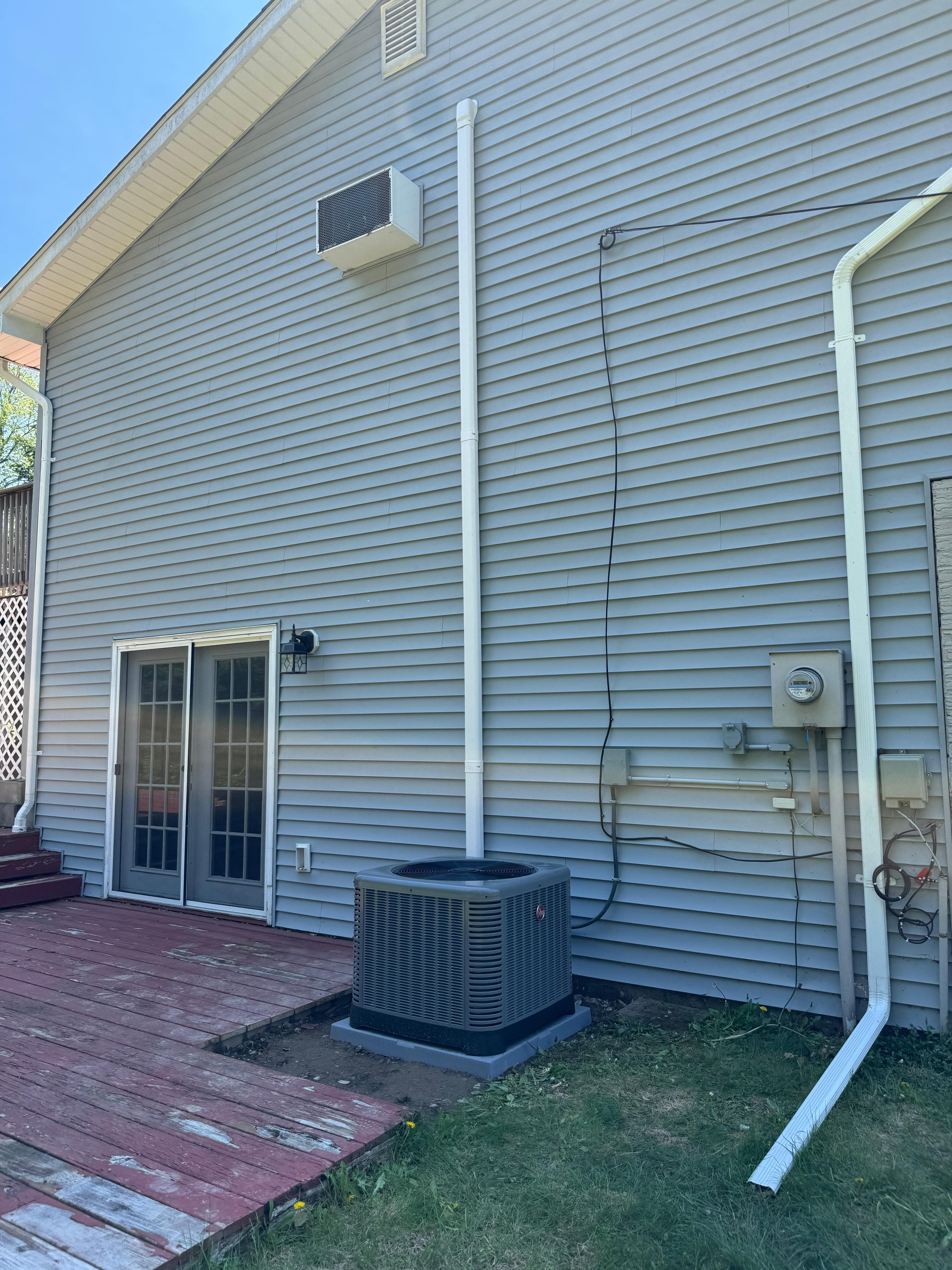 Residential AC condenser unit installed on a back deck