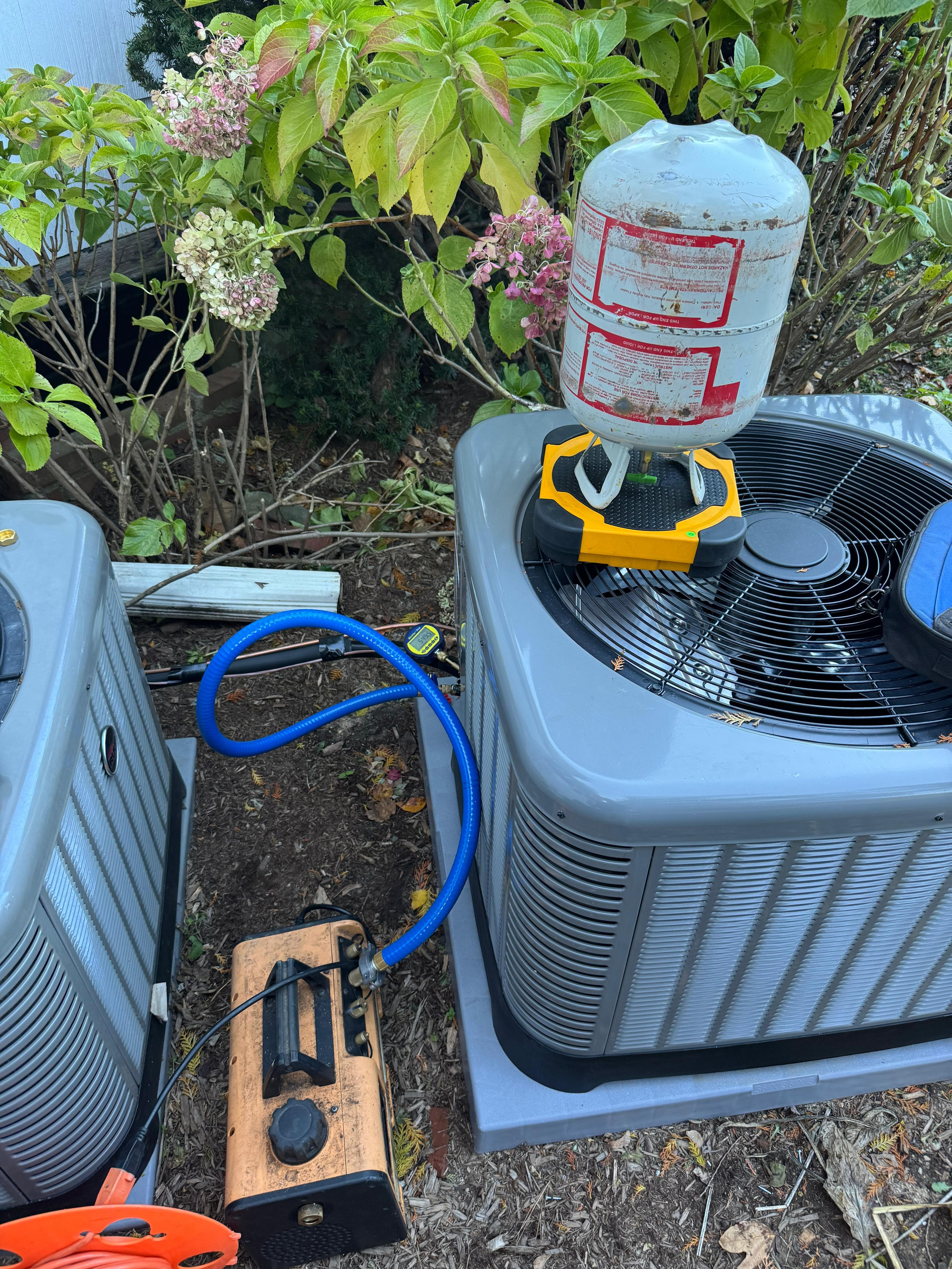 Technician servicing an outdoor AC condenser